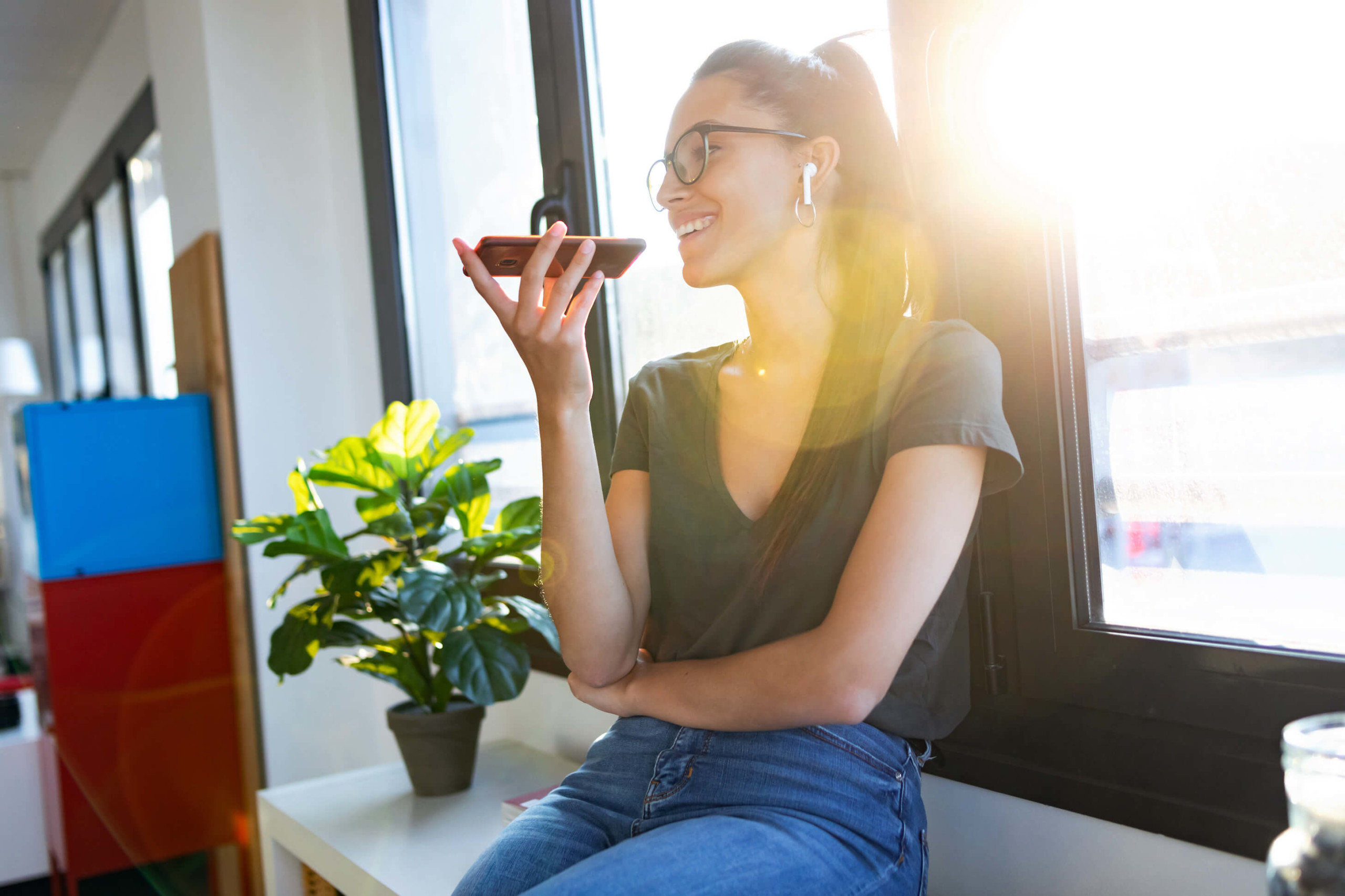Smiling woman speaks into smartphone