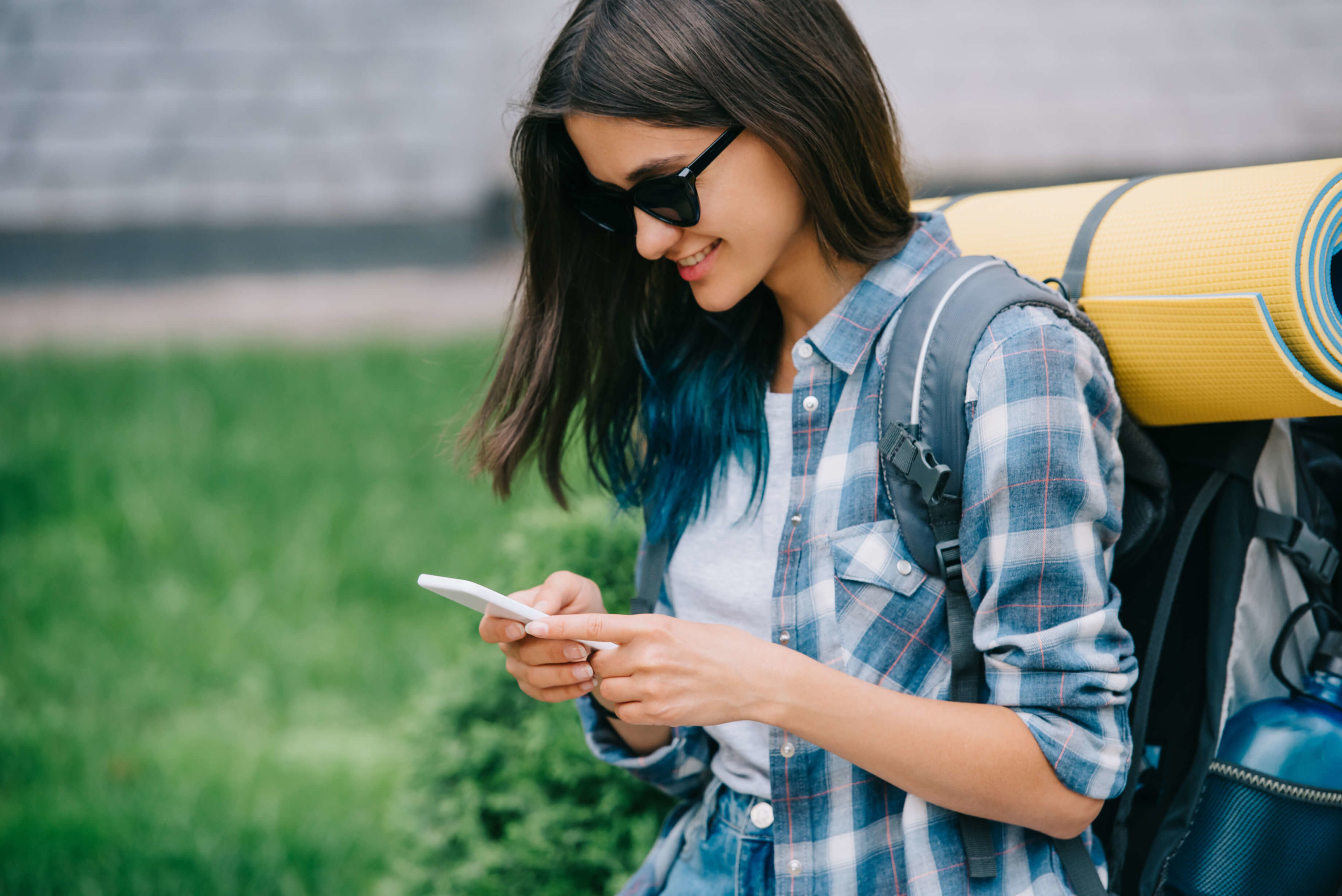 Smiling female traveler on her smartphone